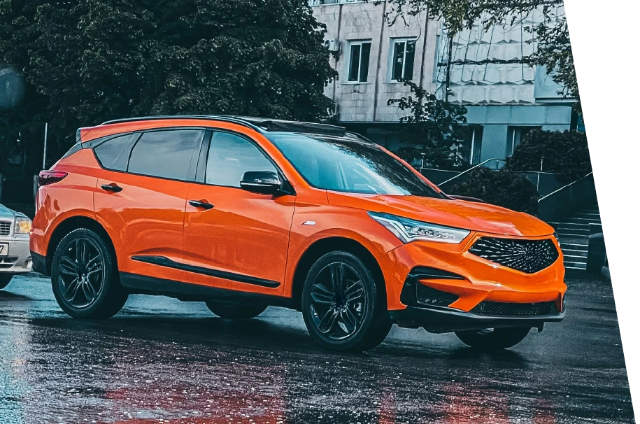 photo of an orange car on a rainy street