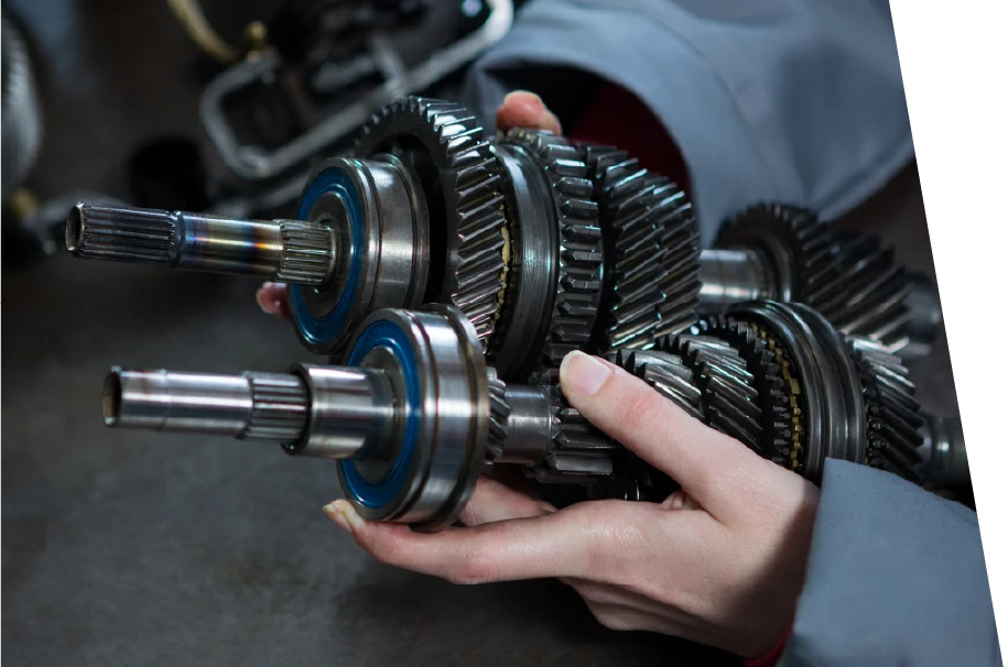 photo of a car service technician holding two new oem parts