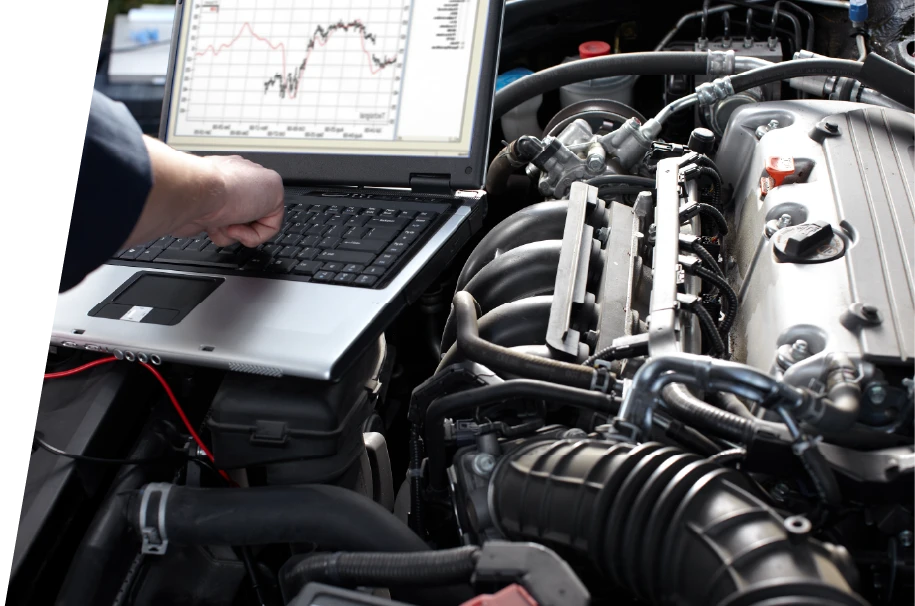 photo of a service technician reviewing car diagnostics on a laptop