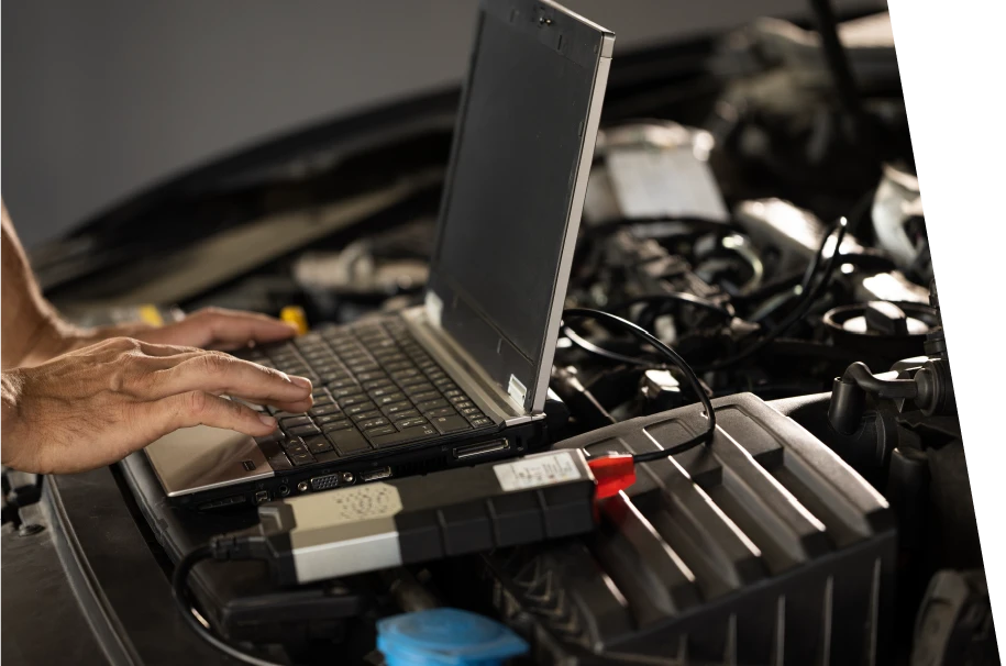 photo of a car service technician using a laptop to troubleshoot error codes of a car warning lights